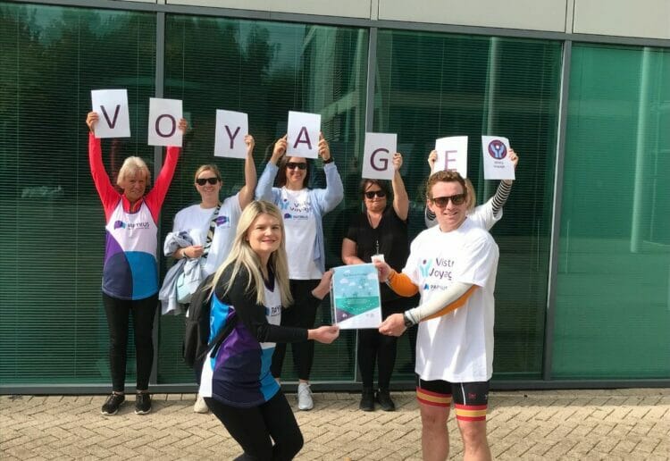 James Davis, right, presents the book to colleagues at Vistry Thames Valley?s head office in Reading before their walk to Sunning Golf Club. Picture: Courtesy of the Vistry Group