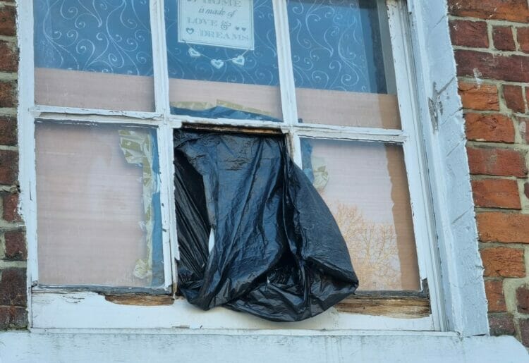 Rochelle Bennett has resorted to using a bin back to secure the window after a panel flew out due to rotting wooden panels at her home in Oxford Road, Reading. Credit: Rochelle Bennet