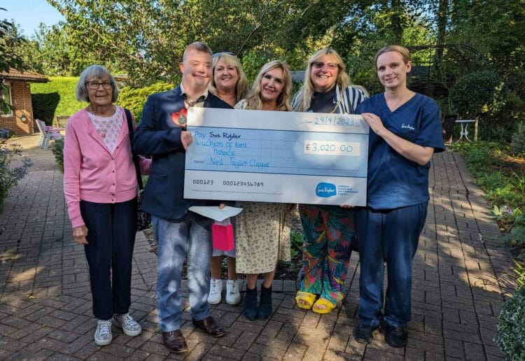 Ned Taylor-Clague presenting a cheque to Sue Ryder Duchess of Kent Hospice team