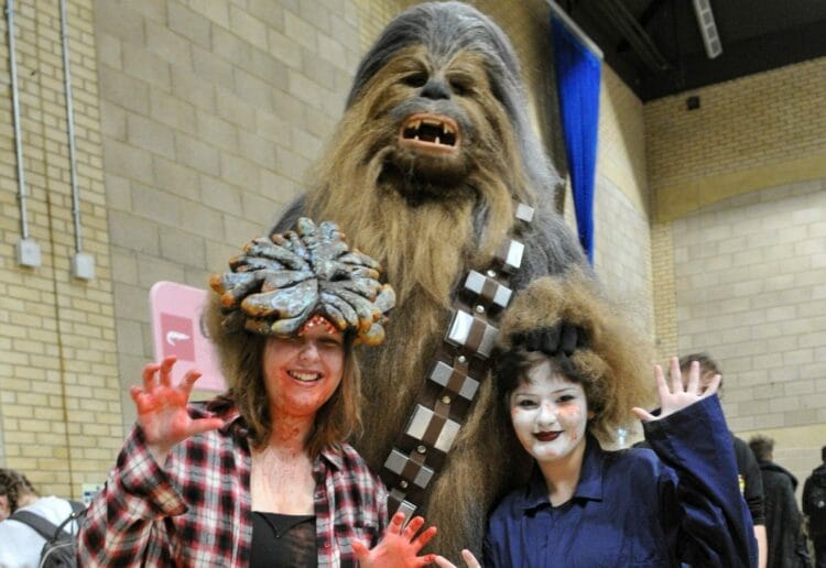 Alex Evans and Emily Philips chew the fat with Chewbacca. Picture: Steve Smyth