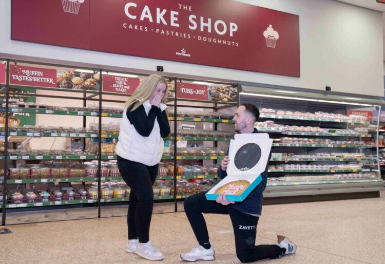 UNITED KINGDOM, Reading 06 February 2025:
Charlie Bullock and Hannah McNaghten get engaged in a Morrisons Supermarket ahead of Valetine?s Day with a personalised romantic cookie saying ?MORRI ME??. 
Credit: Jam Press