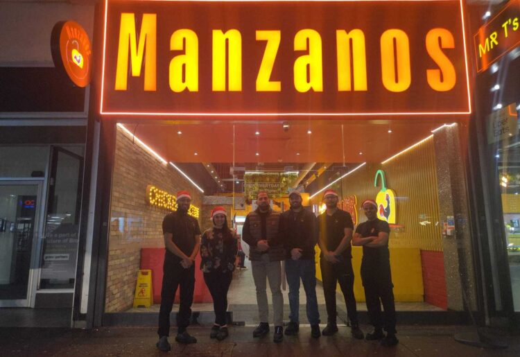 Asam Aziz, the owner of Manzanos Peri Peri with staff at Broad Street Mall in Oxford Road, Reading town centre. Credit: Asam Aziz