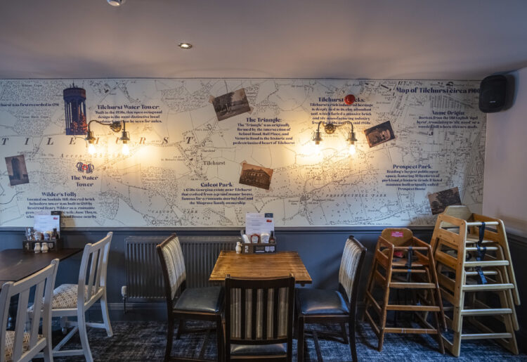 The dining area of the Water Tower pub in Tilehurst, featuring artwork providing information about the heritage of the area. Credit: Greene King