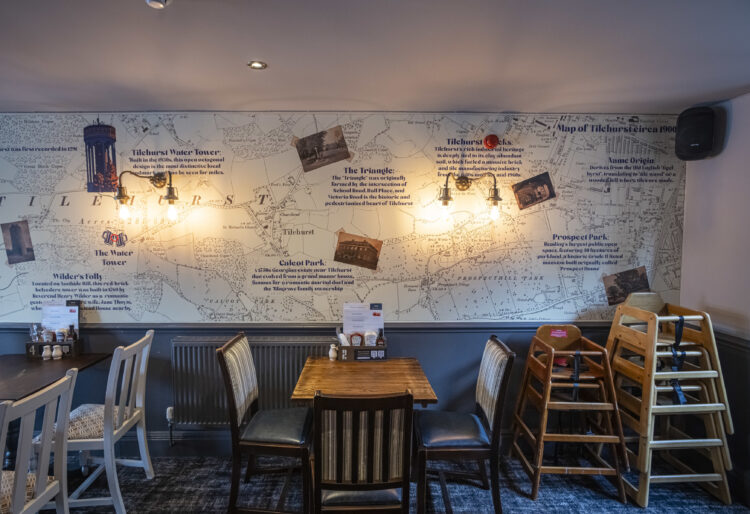 The dining area of the Water Tower pub in Tilehurst, featuring artwork providing information about the heritage of the area. Credit: Greene King