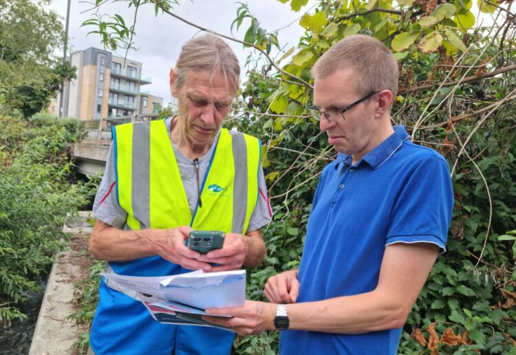John Sharpe and Councillor Richard Walkem (Green, Coley) record water quality results for the Holy Brook adjacent to the A33 in Reading as part of the WaterBlitz. Credit: Sharpe family